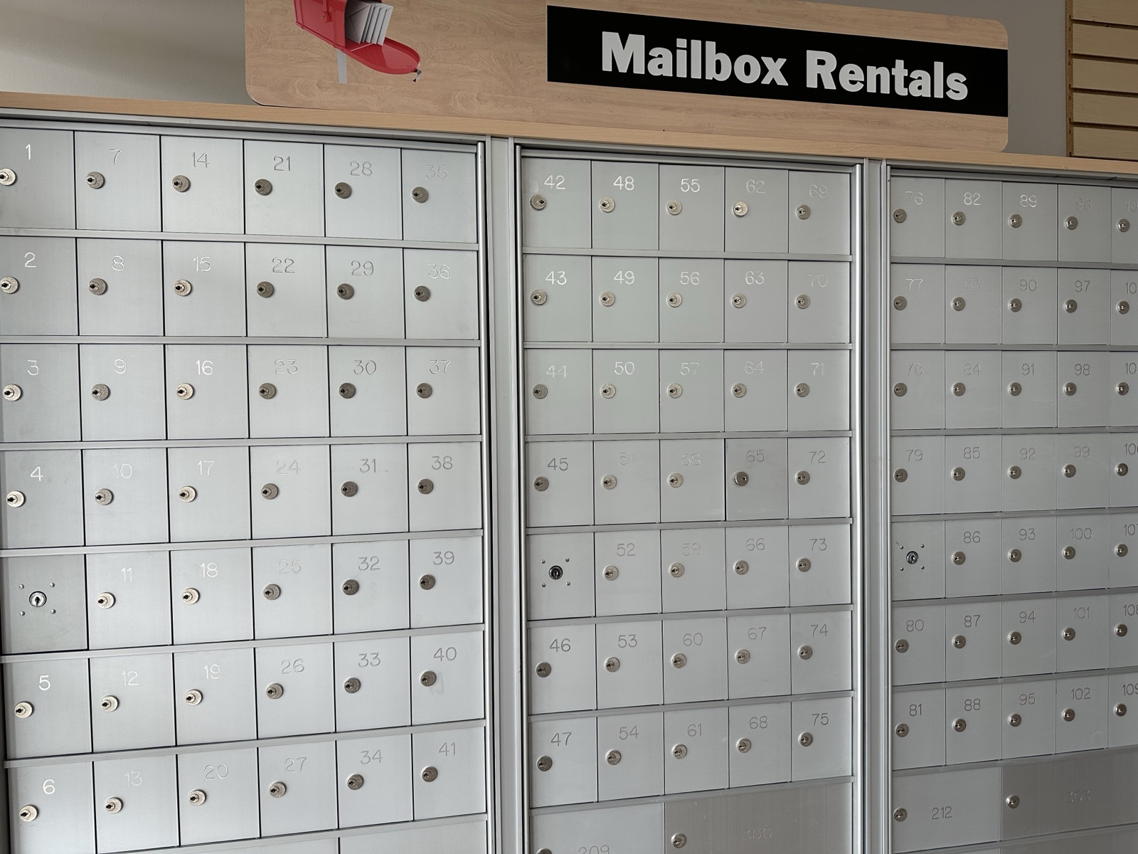 Wall of individual rental mailboxes inside the Postal Hub store