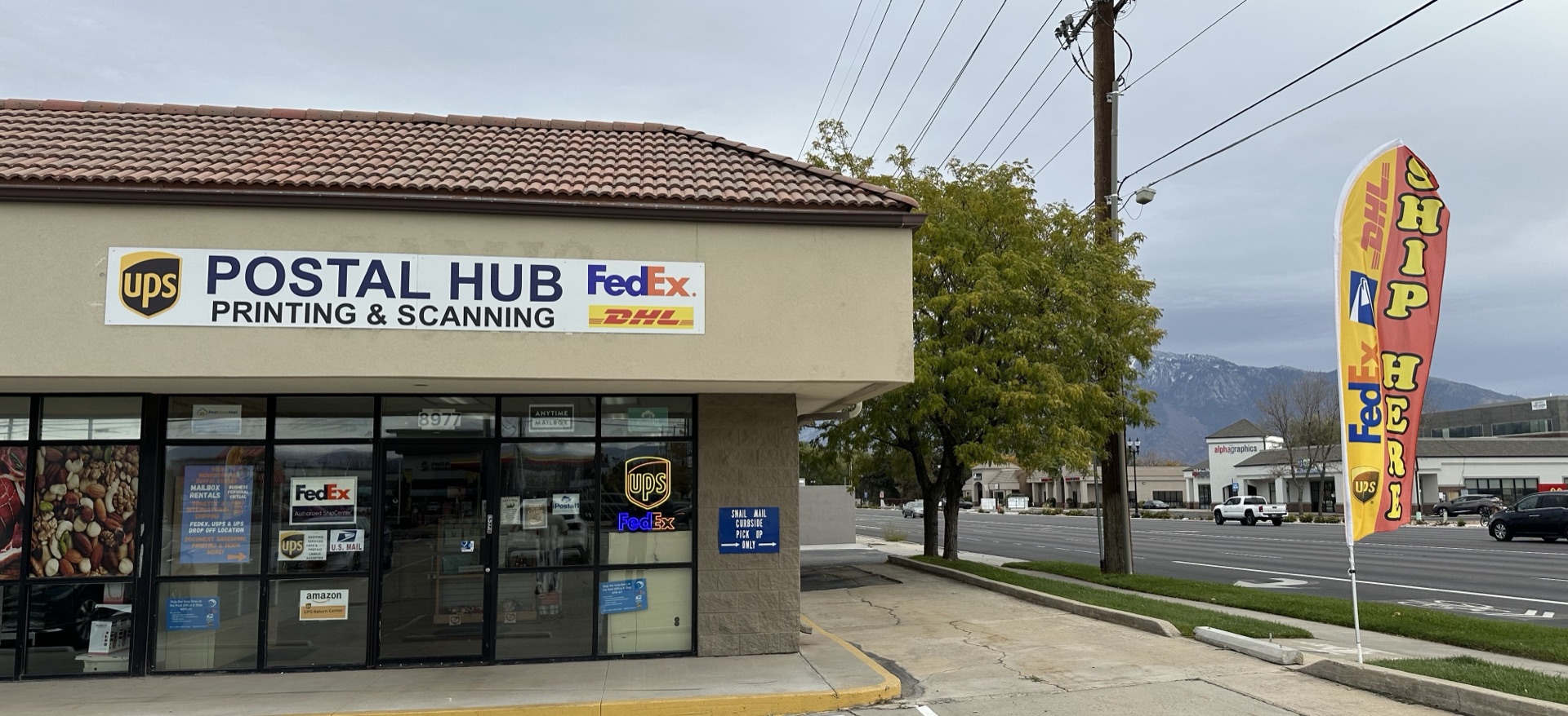 Postal Hub storefront with a UPS, FedEx & DHL ship-here flag